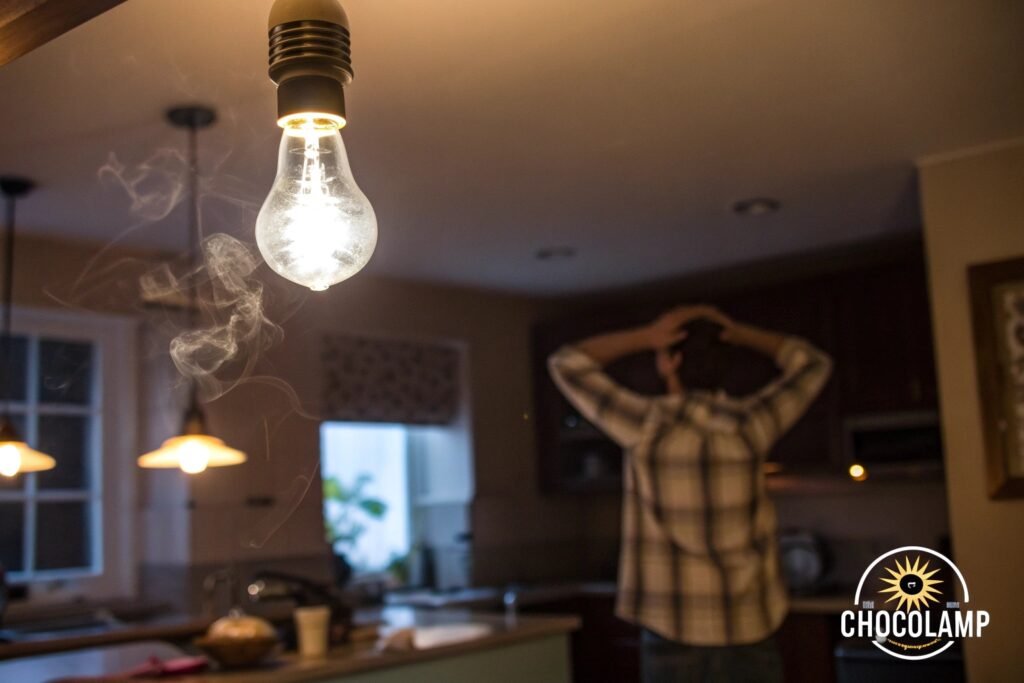 A smoking light bulb in a kitchen with a distressed man in the background, highlighting the dangers of overheating.