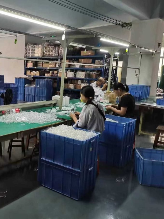 Workers assembling components for night lights on a production line.